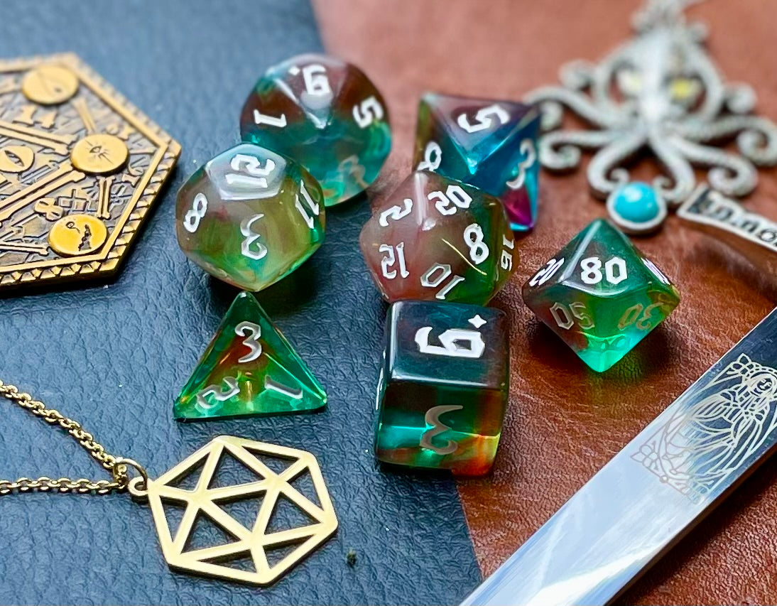 Elemental Gems of the Wind Elves resin polyhedral dice set. Marvel at the sacred stones of the Wind Elves with these fantastic resin dice. Combining translucent green and blues; each dice has its own unique pattern. They are standard 16mm polyhedral dice sets perfect for Tabletop games and RPG's such as pathfinder or dungeons and dragons. This set includes one of each D20, D12, D10, D%, D8, D6, D4.