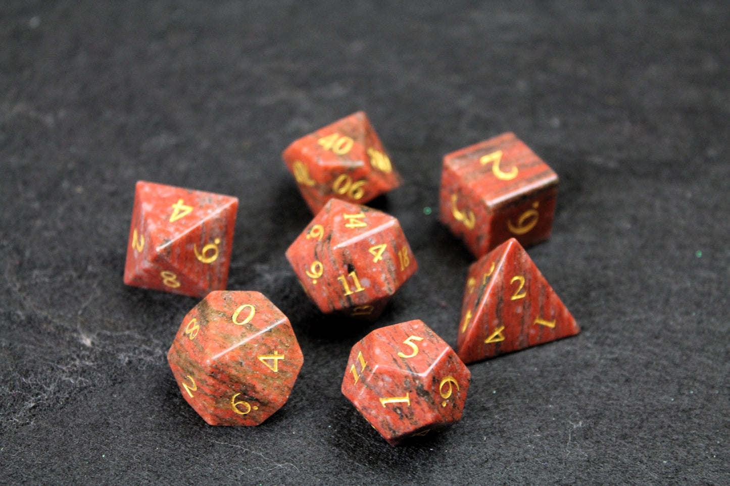 Sesame Red Granite Gemstone Dice Set
Polished Sesame Red Granite gemstone with gold numbers dice set
Roll in style with these polyhedral dice sets perfect for Tabletop games and RPG's such as pathfinder or dungeons and dragons.
This set includes one of each D20, D12, D10, D%, D8, D6, D4.
Available both with or without a PU leather dice storage box.