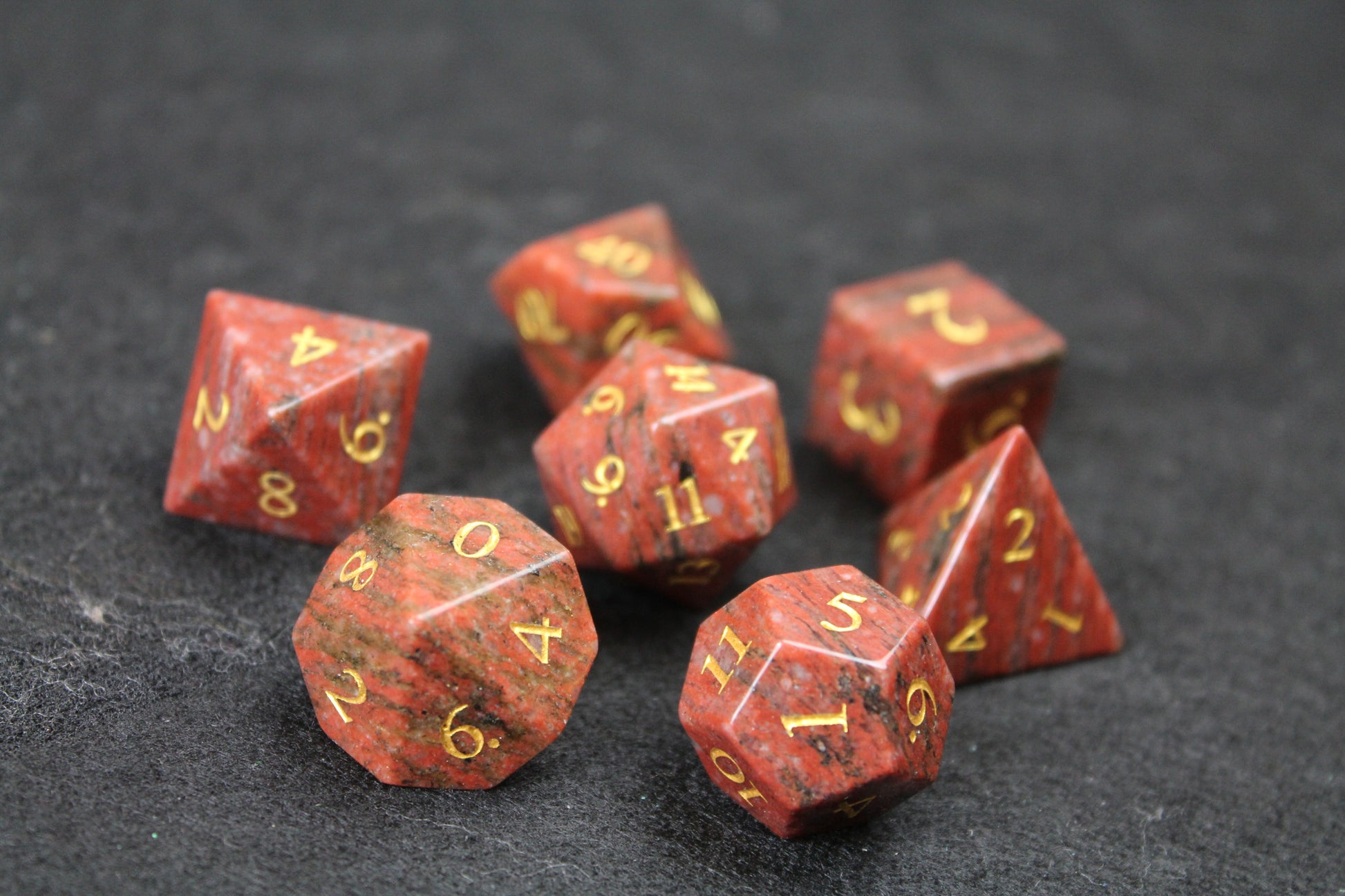 Sesame Red Granite Gemstone Dice Set
Polished Sesame Red Granite gemstone with gold numbers dice set
Roll in style with these polyhedral dice sets perfect for Tabletop games and RPG's such as pathfinder or dungeons and dragons.
This set includes one of each D20, D12, D10, D%, D8, D6, D4.
Available both with or without a PU leather dice storage box.