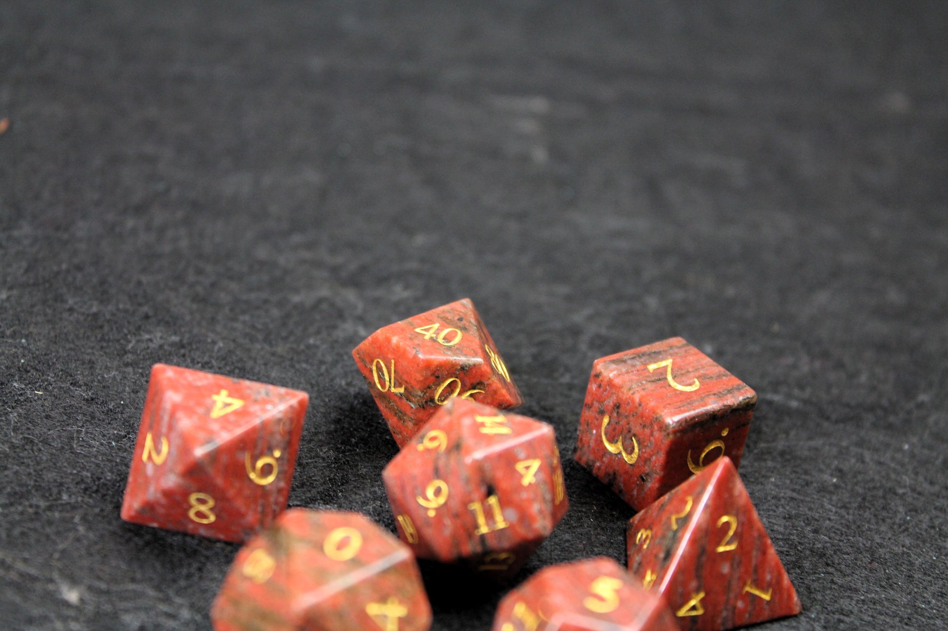 Sesame Red Granite Gemstone Dice Set
Polished Sesame Red Granite gemstone with gold numbers dice set
Roll in style with these polyhedral dice sets perfect for Tabletop games and RPG's such as pathfinder or dungeons and dragons.
This set includes one of each D20, D12, D10, D%, D8, D6, D4.
Available both with or without a PU leather dice storage box.