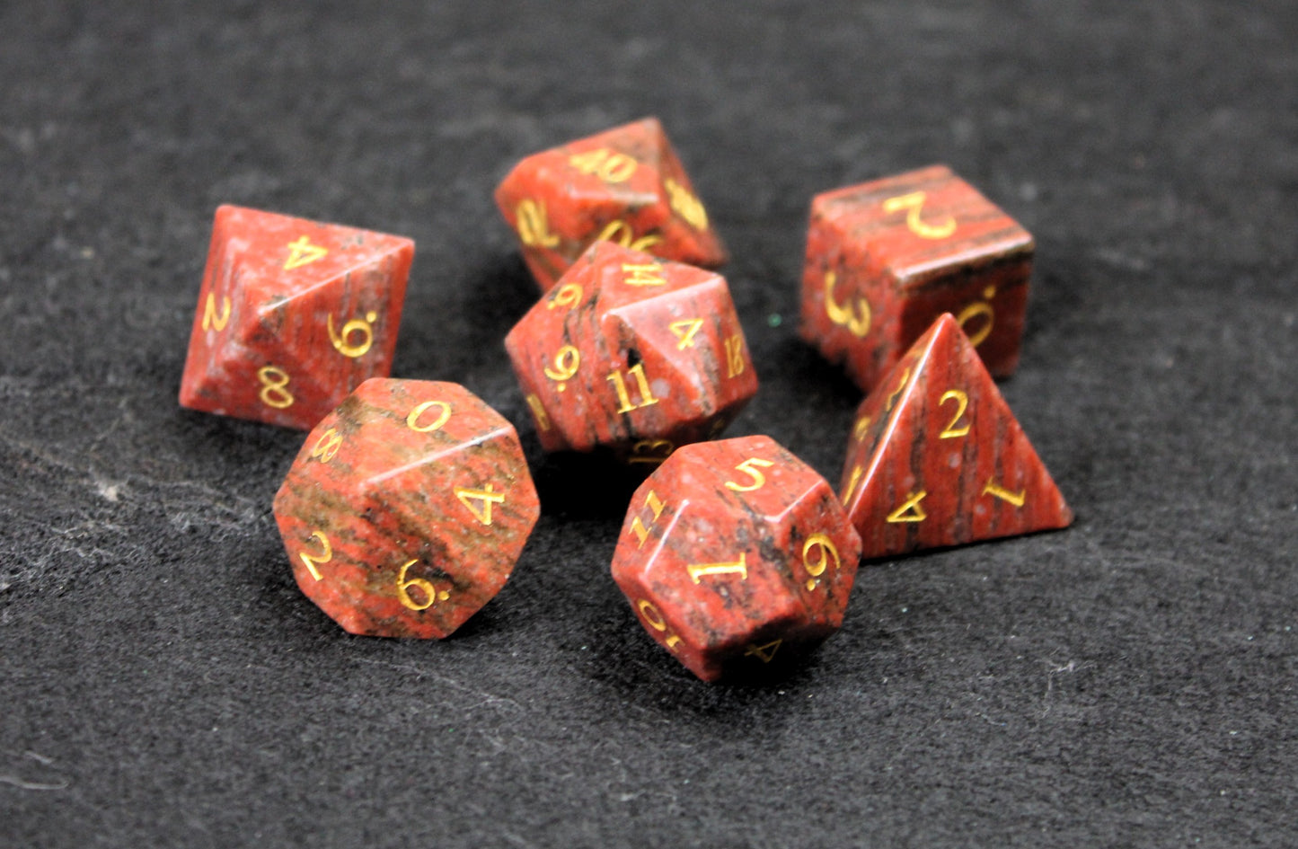 Sesame Red Granite Gemstone Dice Set
Polished Sesame Red Granite gemstone with gold numbers dice set
Roll in style with these polyhedral dice sets perfect for Tabletop games and RPG's such as pathfinder or dungeons and dragons.
This set includes one of each D20, D12, D10, D%, D8, D6, D4.
Available both with or without a PU leather dice storage box.