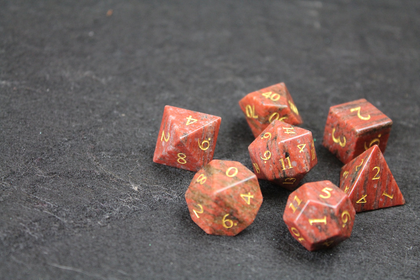 Sesame Red Granite Gemstone Dice Set
Polished Sesame Red Granite gemstone with gold numbers dice set
Roll in style with these polyhedral dice sets perfect for Tabletop games and RPG's such as pathfinder or dungeons and dragons.
This set includes one of each D20, D12, D10, D%, D8, D6, D4.
Available both with or without a PU leather dice storage box.