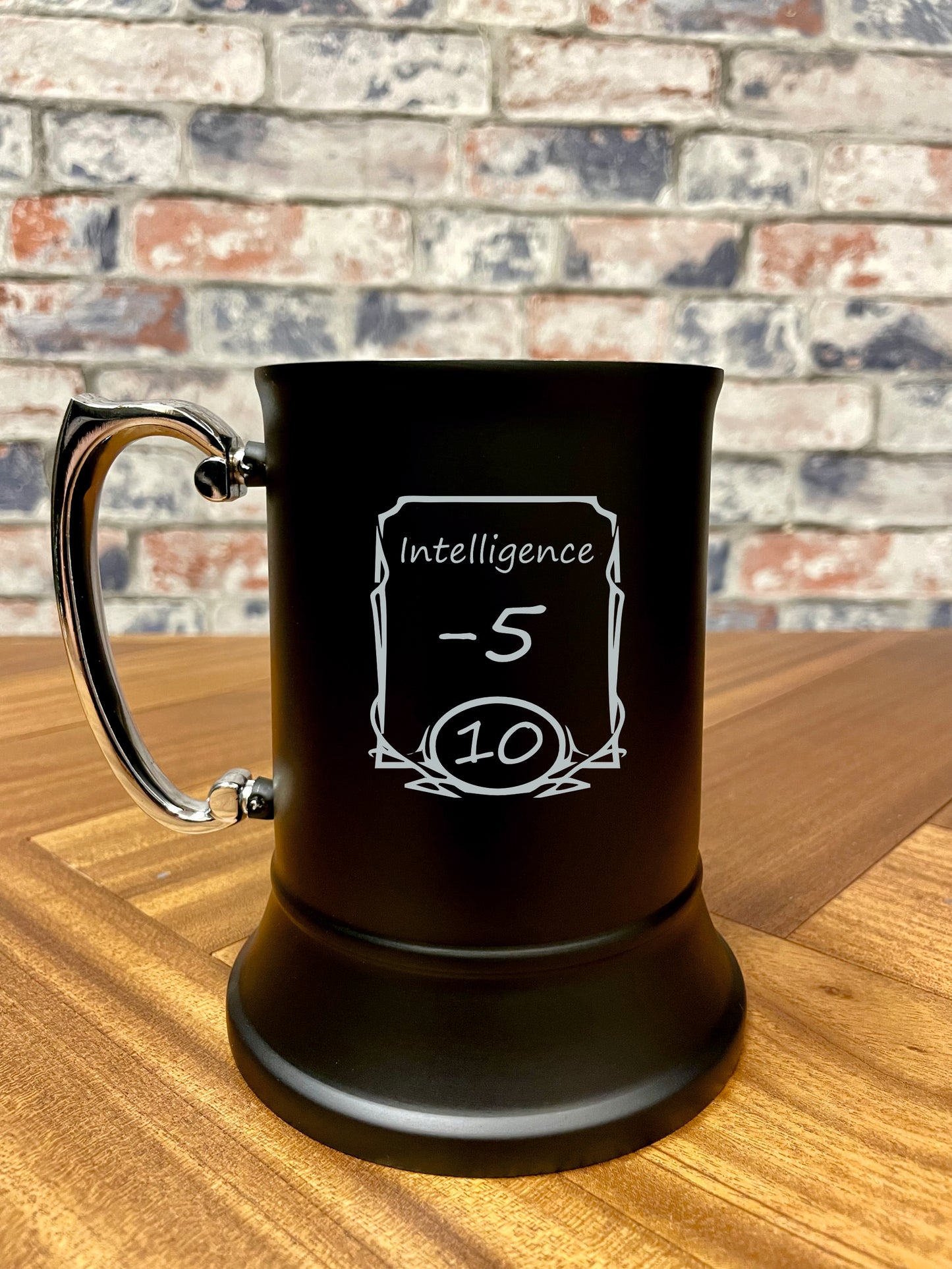 Intelligence -5 Engraved stainless steel drinking tankard.
Black enameled tankard engraved with fun Intelligence -5 stats change design.
Standing 13cm tall and holding 500ml, you'll stay refreshed during even the most tense combat!
By engraving the coating off the stainless steel it wont fade or wear; keeping your tankard looking its best for longer.
Perfect for tabletop gaming, dungeons and dragons TTRPG's, LARP and much more. Treat yourself and your party!
