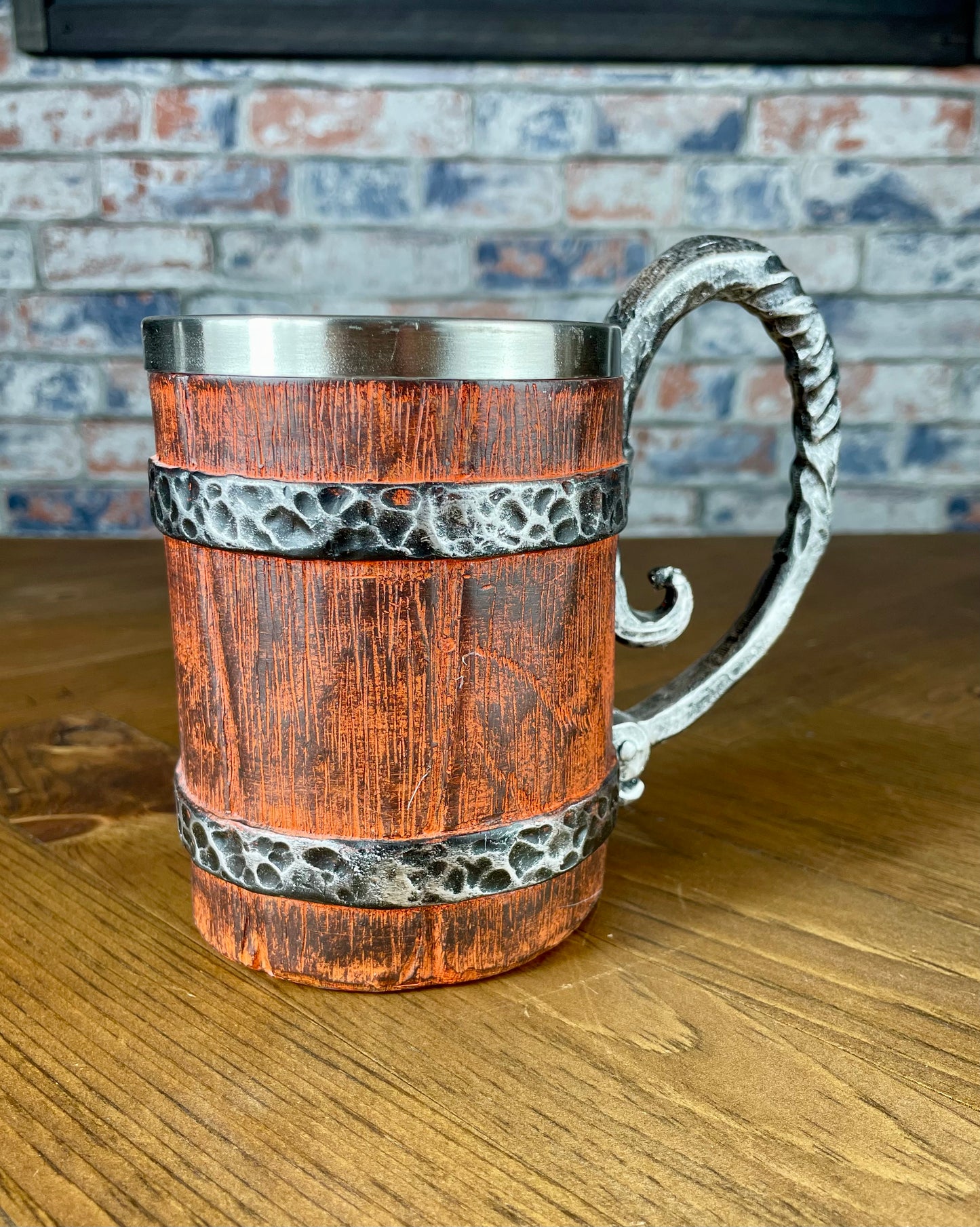 Medieval Viking Style Decorative Resin Drinking Tankard With Stainless Steel Insert. Drink in style with our highly decorative tankard with wood effect panels, metal banding and rustic style handle. Holding 500ml you can drink with your clan in style. Perfect for decorating home bars, cosplay, tabletop gaming and all fans of Norse mythology and Viking decoration.