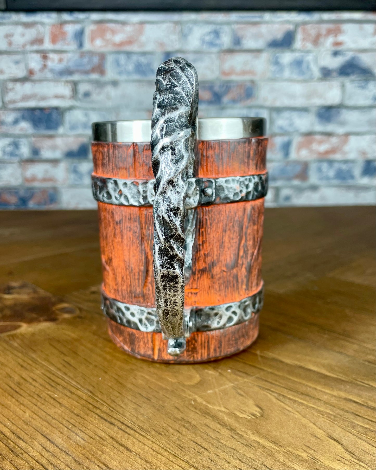 Medieval Viking Style Decorative Resin Drinking Tankard With Stainless Steel Insert. Drink in style with our highly decorative tankard with wood effect panels, metal banding and rustic style handle. Holding 500ml you can drink with your clan in style. Perfect for decorating home bars, cosplay, tabletop gaming and all fans of Norse mythology and Viking decoration.