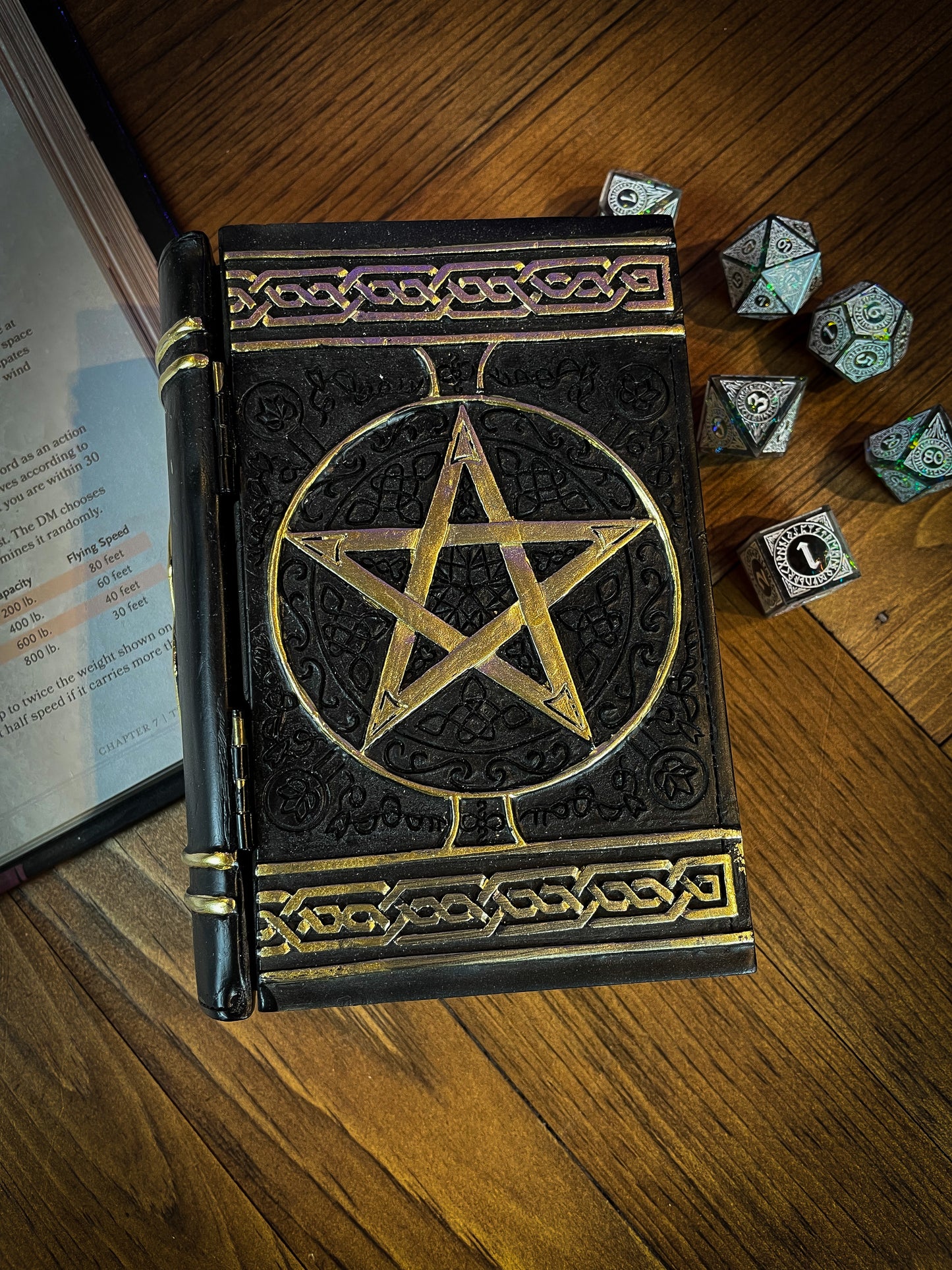 This fantastic box can subtly blend into any arcane library. Taking form of an ancient book, bound in black leather. The lid of the box features a raised golden pentagram with detailed patterns decorating the top and bottom of the cover. Free UK Delivery with Fandomonium