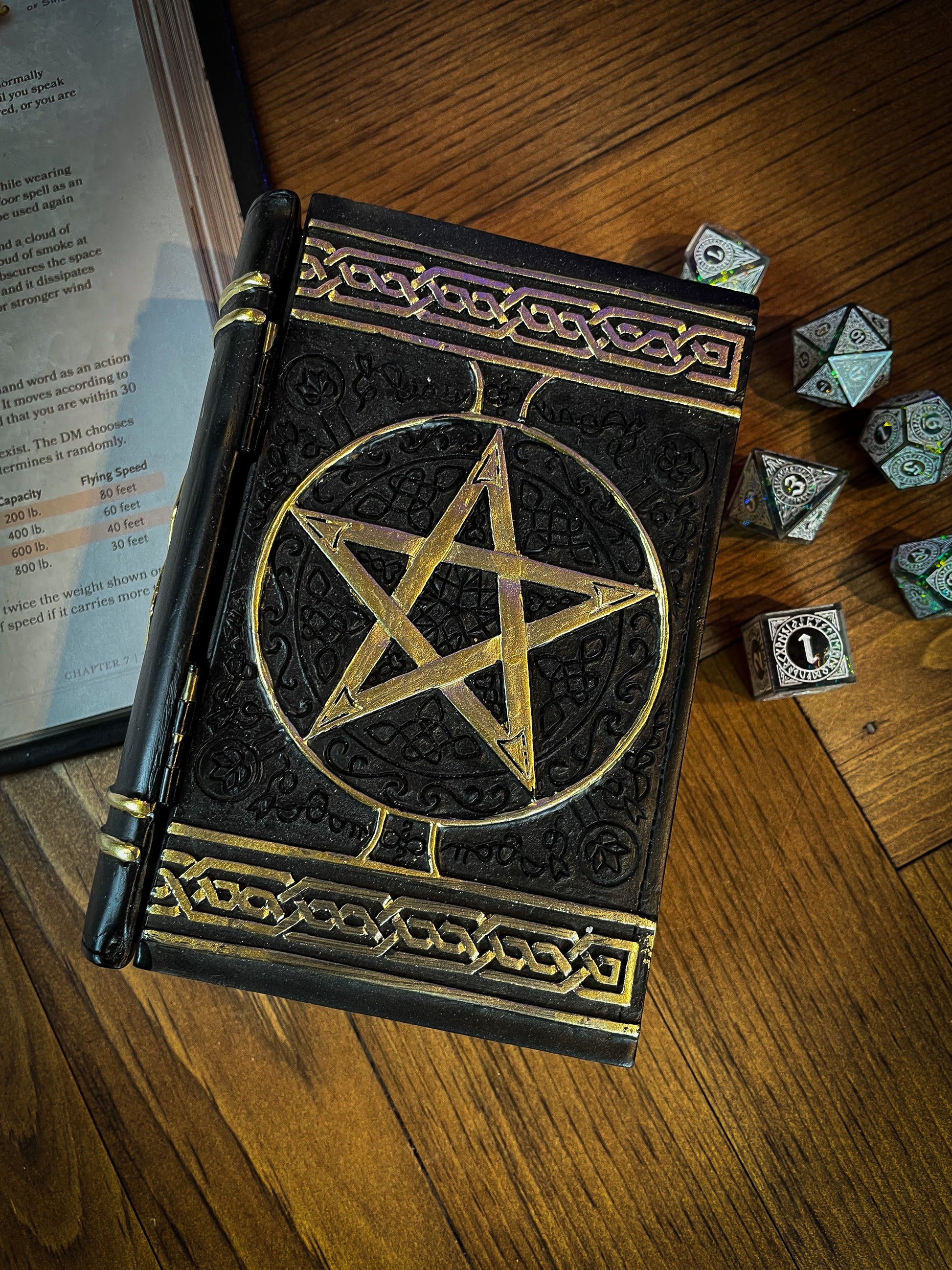This fantastic box can subtly blend into any arcane library. Taking form of an ancient book, bound in black leather. The lid of the box features a raised golden pentagram with detailed patterns decorating the top and bottom of the cover. Free UK Delivery with Fandomonium