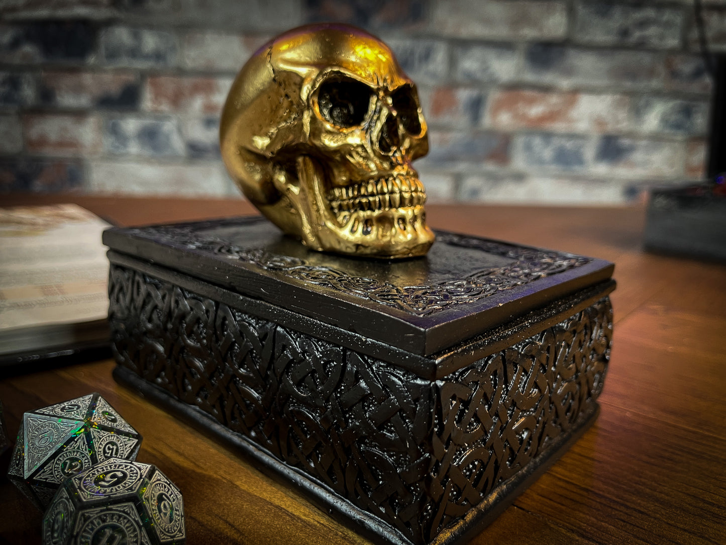 This expertly crafted box will bring macabre opulence to any room! Sat on a large black box, covered in Celtic patterns, is a small golden skull, simple yet strikingly stylish. Lift the skull upwards to reveal the perfect place to store all of your treasure. Free UK Delivery by Fandomonium