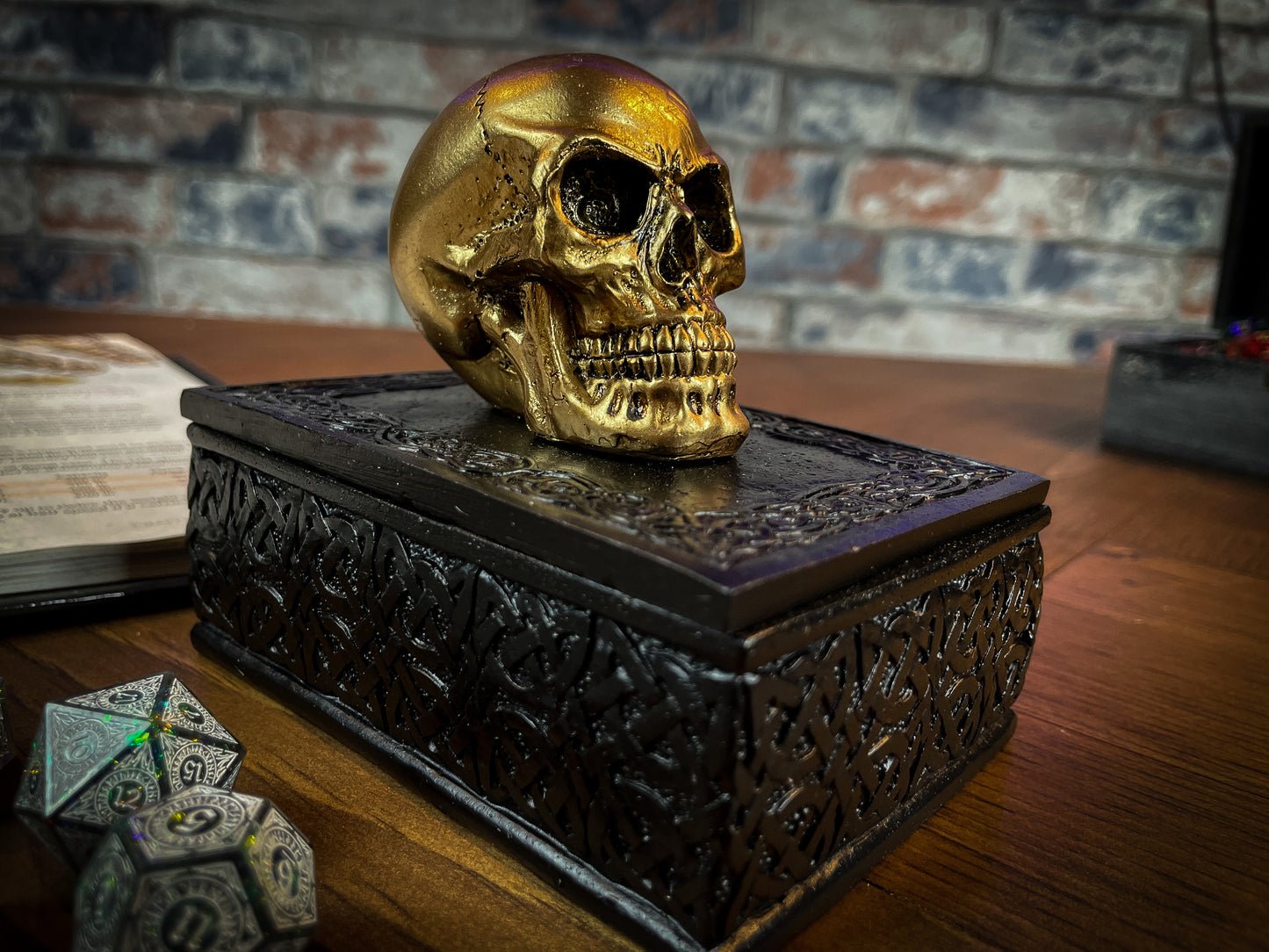 This expertly crafted box will bring macabre opulence to any room! Sat on a large black box, covered in Celtic patterns, is a small golden skull, simple yet strikingly stylish. Lift the skull upwards to reveal the perfect place to store all of your treasure. Free UK Delivery by Fandomonium