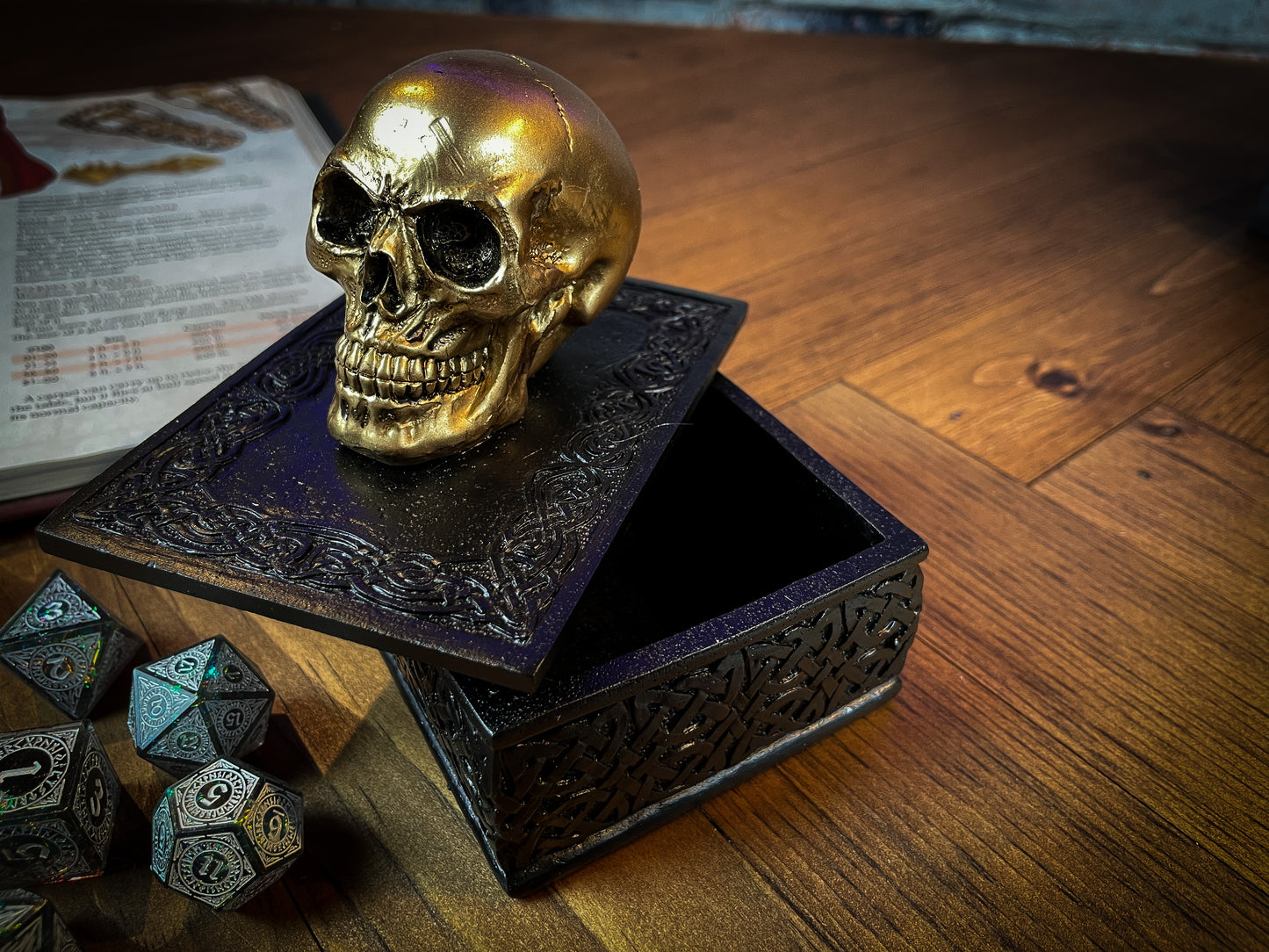 This expertly crafted box will bring macabre opulence to any room! Sat on a large black box, covered in Celtic patterns, is a small golden skull, simple yet strikingly stylish. Lift the skull upwards to reveal the perfect place to store all of your treasure. Free UK Delivery by Fandomonium