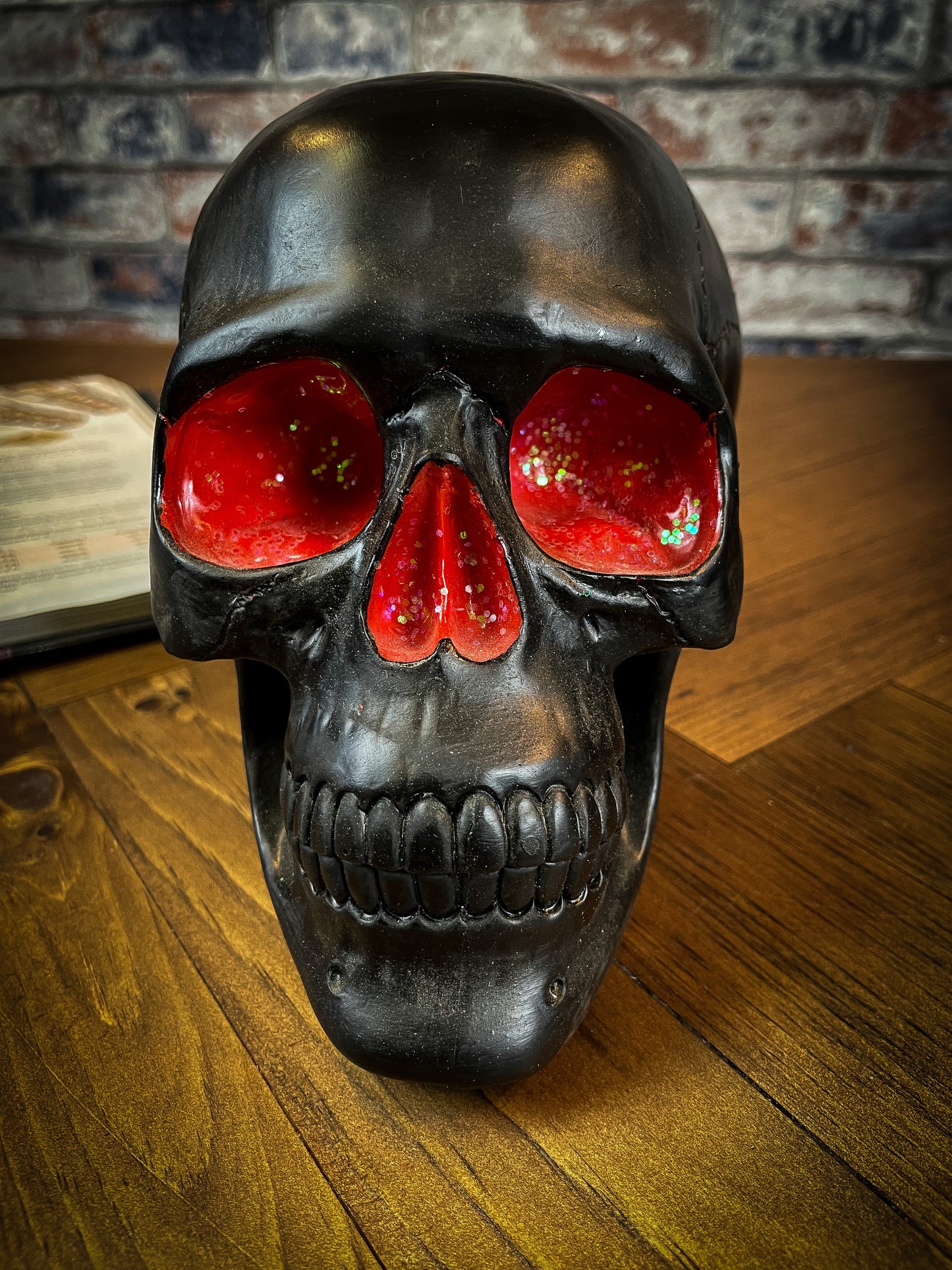 The most unassuming facade can hide the most scintillating interior. This matte black skull has eyes and nose holes that open up to a sparkling red world. A large crack at the side of the skull reveals an enchanting red crystal geode within, sparkling in the light. Free UK Delivery by Fandomonium
