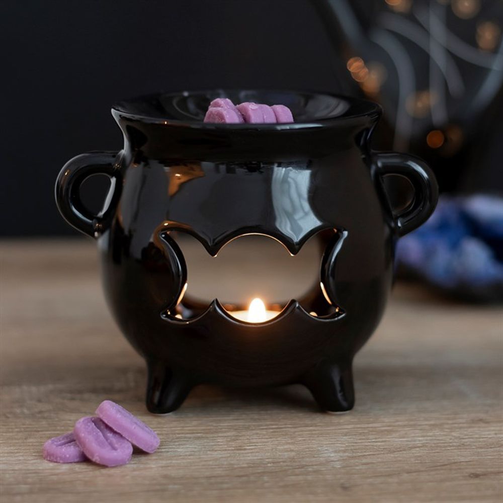 Triple Moon Cauldron Oil Burner Glossy black cauldron-shaped ceramic oil burner with a triple moon cut-out design. A fantastic gift for any of your coven. Free UK delivery by Fandomonium