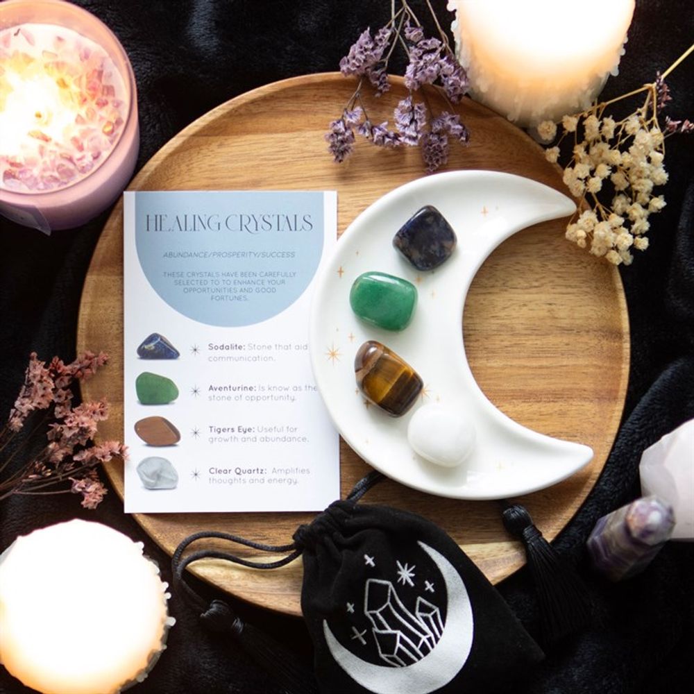 Success Healing Crystal Set with Moon Trinket Dish This stunning set of healing crystals comes with four crystal tumblestones to help attract prosperity and success. Includes a crescent moon trinket dish, matching information card and a printed drawstring, making this a meaningful gift for those in need of some extra care. Stones include; sodalite, aventurine, tiger's eye and clear quartz. Free UK delivery by Fandomonium