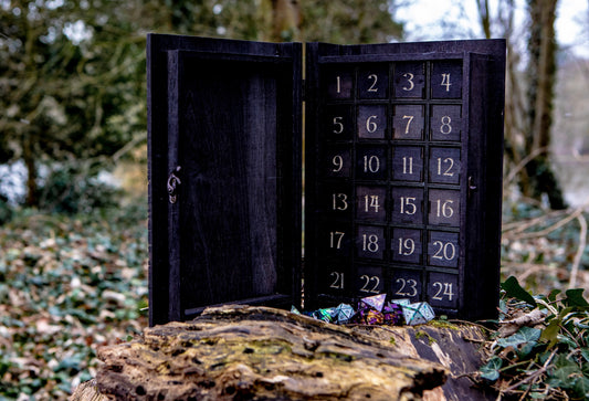 opened wooden book style advent calendar in black showing individual boxes and dice