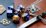 Elemental gold and black resin polyhedral dice set.  Unleash the fury of the fire elemental spirits with these fantastic resin dice. Combining gold and black swirls; each dice has its own unique pattern.
