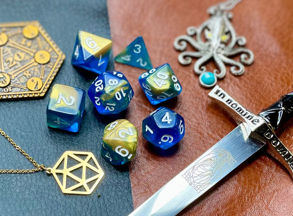 Elemental Gem Rising Phoenix Polyhedral Dice Set  Awaken the elements with these fantastic resin dice. Combining blue and gold translucent resin; each dice has its own unique pattern.  They are standard 16mm polyhedral dice sets perfect for Tabletop games and RPG's such as pathfinder or dungeons and dragons.  This set includes one of each D20, D12, D10, D%, D8, D6, D4.