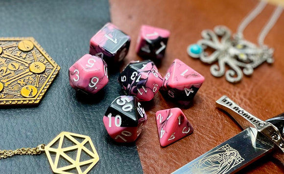 Elemental Pink and Black resin polyhedral dice set.  Awaken the elements with these fantastic resin dice. Combining vibrant pink and black swirls; each dice has its own unique pattern.  They are standard 16mm polyhedral dice sets perfect for Tabletop games and RPG's such as pathfinder or dungeons and dragons.  This set includes one of each D20, D12, D10, D%, D8, D6, D4.