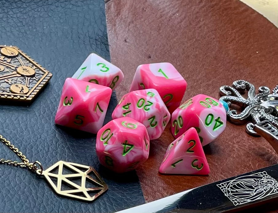 Elemental Pink and White resin polyhedral dice set.  Awaken the elements with these fantastic resin dice. Combining vibrant pink with white swirls; each dice has its own unique pattern.  They are standard 16mm polyhedral dice sets perfect for Tabletop games and RPG's such as pathfinder or dungeons and dragons.  This set includes one of each D20, D12, D10, D%, D8, D6, D4.