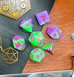 Elemental Purple and Green resin polyhedral dice set.  Awaken the elements with these fantastic resin dice. Combining vibrant pink with white swirls; each dice has its own unique pattern.  They are standard 16mm polyhedral dice sets perfect for Tabletop games and RPG's such as pathfinder or dungeons and dragons.  This set includes one of each D20, D12, D10, D%, D8, D6, D4.