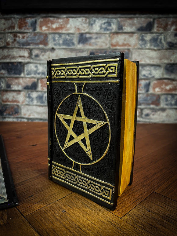 This fantastic box can subtly blend into any arcane library. Taking form of an ancient book, bound in black leather. The lid of the box features a raised golden pentagram with detailed patterns decorating the top and bottom of the cover. Free UK Delivery with Fandomonium