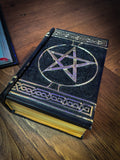 This fantastic box can subtly blend into any arcane library. Taking form of an ancient book, bound in black leather. The lid of the box features a raised golden pentagram with detailed patterns decorating the top and bottom of the cover. Free UK Delivery with Fandomonium