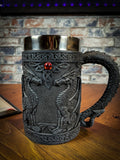 Drink with Dragons with this deliciously Gothic tankard. Black as carved obsidian, the body of the tankard depicts Dragons in profile, sitting and looking at each other. Between their unblinking gazes, a red gem sits at the apex of a Celtic knot pattern. Free UK delivery with Fandomonium