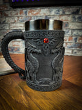Drink with Dragons with this deliciously Gothic tankard. Black as carved obsidian, the body of the tankard depicts Dragons in profile, sitting and looking at each other. Between their unblinking gazes, a red gem sits at the apex of a Celtic knot pattern. Free UK delivery with Fandomonium