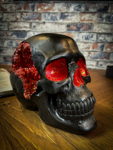 The most unassuming facade can hide the most scintillating interior. This matte black skull has eyes and nose holes that open up to a sparkling red world. A large crack at the side of the skull reveals an enchanting red crystal geode within, sparkling in the light. Free UK Delivery by Fandomonium