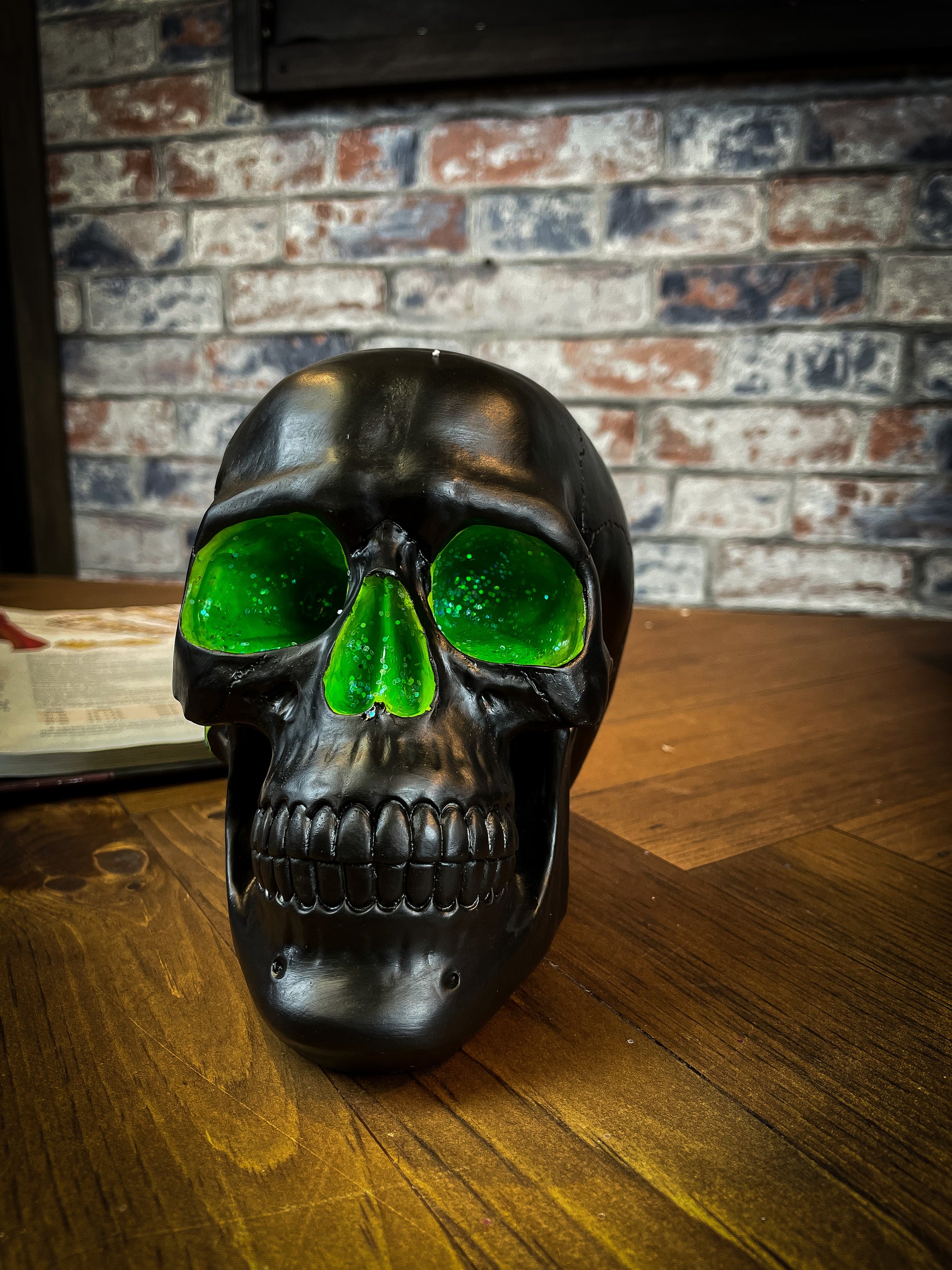 The most unassuming facade can hide the most scintillating interior. This matte black skull has eyes and nose holes that open up to a sparkling green world. A large crack at the side of the skull reveals an enchanting green crystal geode within, sparkling in the light. Free UK Delivery by Fandomonium