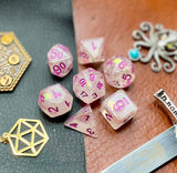 Glitter Shimmer With Pink Font Polyhedral Dice Set  Traverse the galaxy with these unique dice. Combining frosted resin with shimmer and pink font.  They are standard 16mm polyhedral dice sets perfect for Tabletop games and RPG's such as pathfinder or dungeons and dragons.  This set includes one of each D20, D12, D10, D%, D8, D6, D4.