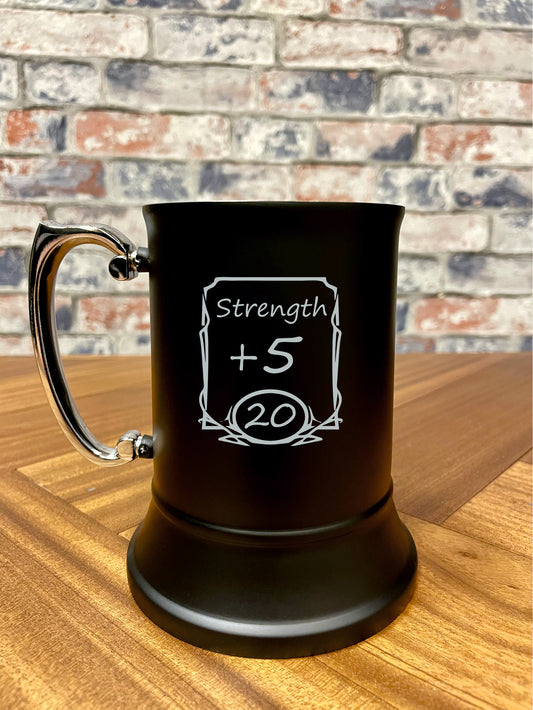 Strength +5 Engraved stainless steel drinking tankard.

Black enameled tankard engraved with fun Strength +5 stats change design.

Standing 13cm tall and holding 500ml, you'll stay refreshed during even the most tense combat!

By engraving the coating off the stainless steel it wont fade or wear; keeping your tankard looking its best for longer.

Perfect for tabletop gaming, dungeons and dragons TTRPG's, LARP and much more. Treat yourself and your party!