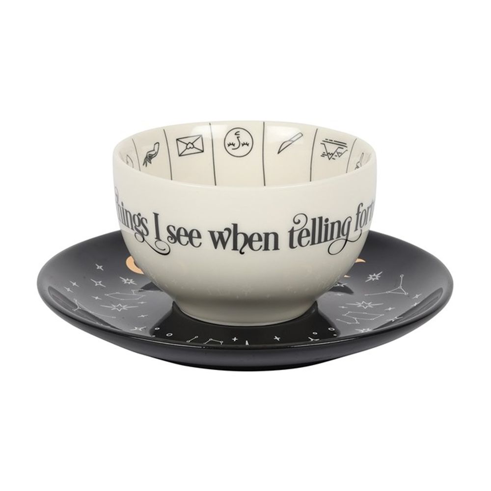 Fortune Telling Ceramic Teacup  A stunning and unique tea cup to be used for reading tea leaves. Features a variety of fortune telling and astrological symbols accented by gold foil, a contrasting black saucer, and mystical 'Mysterious things I see when telling fortunes in tea' text. Truly a piece to be treasured. By Fandomonium