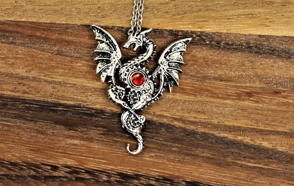 Metal dragon pendant necklace with inset cogs and wheels and red heart
