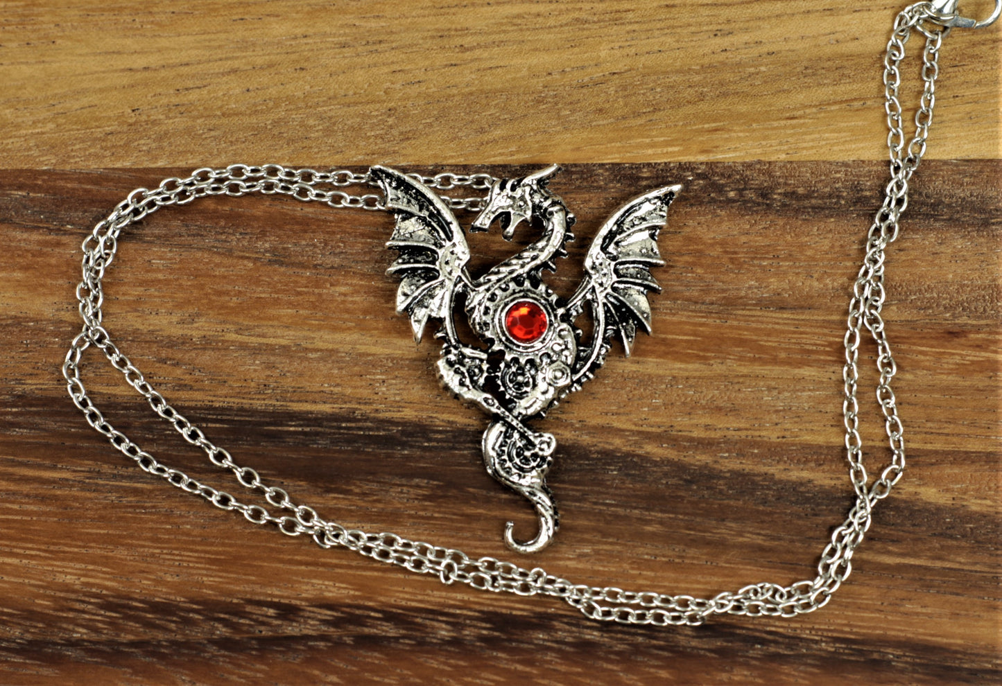 Metal dragon pendant necklace with inset cogs and wheels and red heart