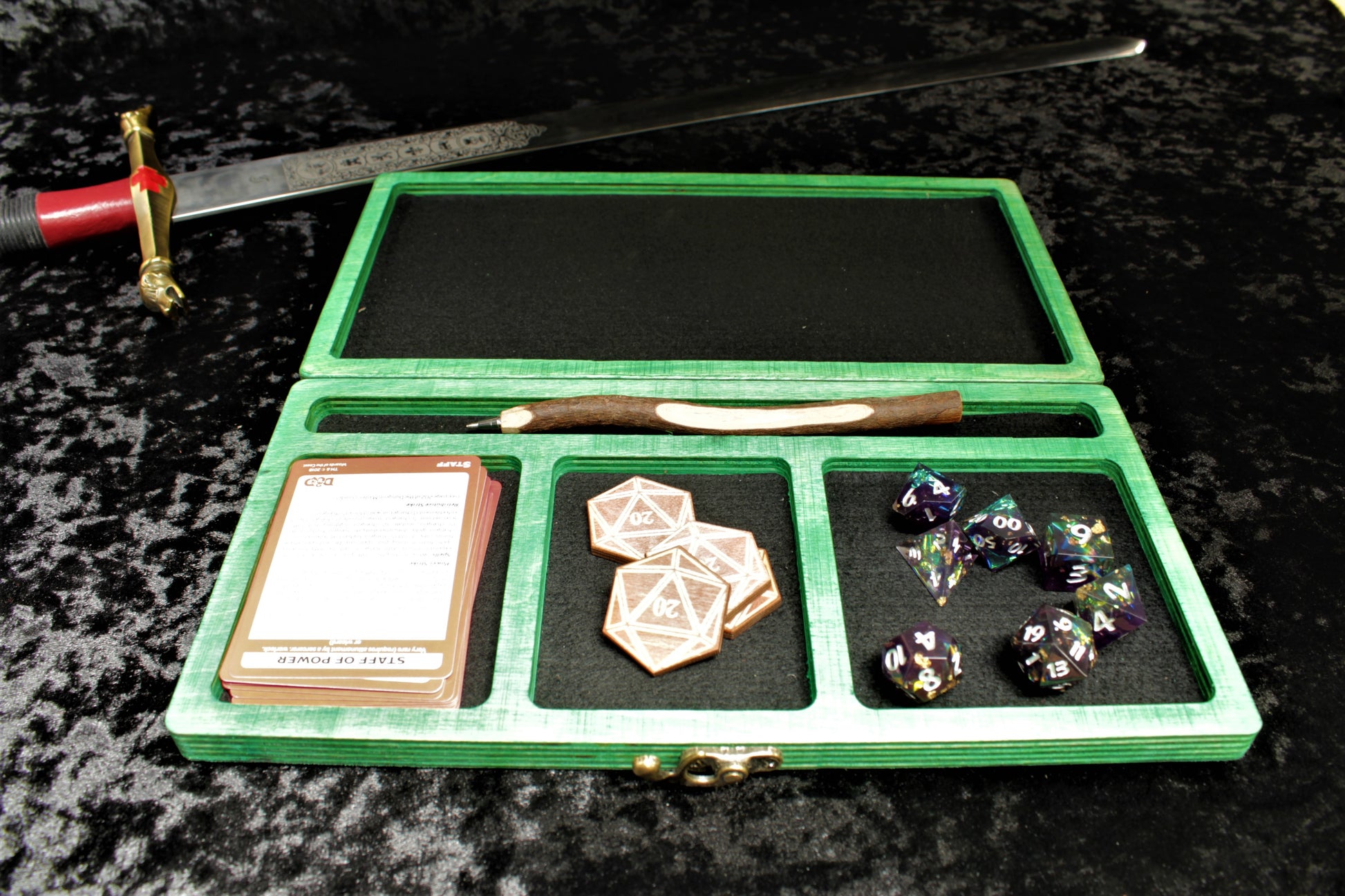 Dragon Scale Dice Box, Accessory Storage and Roll Tray.

Hand finished dice box for storing dice, cards, counters and accessories with handy pen storage and in built roll tray. Choose from 8 vibrant colour finished to make your box unique to you. Complete with our unique dragon scale design, metal corner protectors and clasp